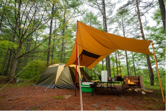 山の中で広げたテントとキャンプ道具
