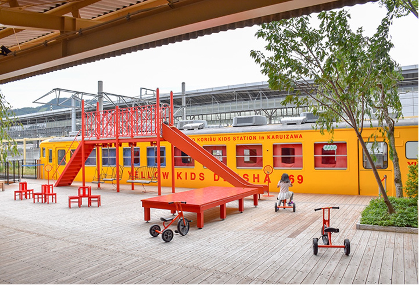 子供が遊ぶ公園と黄色の電車
